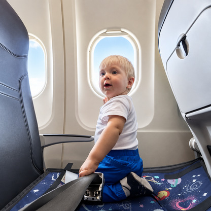 lit de voyage bébé bleu à genoux tirant ceinture devant hublot