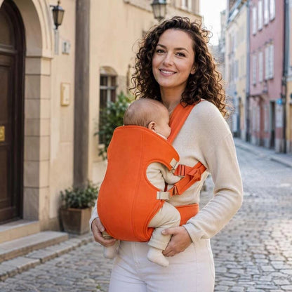 porte bébé orange maman ruelle Paris heureuse sourire